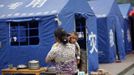 A mother holds her son as she walks past tents at a village, the second day after a strong 6.6 magnitude earthquake hit the remote, mostly rural and mountainous Lushan county, Sichuan province, April 21, 2013. Rescuers struggled to reach a remote, rural corner of southwestern China on Sunday as the toll of the dead and missing from the country's worst earthquake in three years climbed to 203 with almost 1,000 serious injuries. The 6.6 magnitude quake struck in Lushan county, near the city of Ya'an in the southwestern province of Sichuan, close to where a devastating 7.9 quake hit in May 2008, killing 70,000. REUTERS/Aly Song (CHINA - Tags: DISASTER ENVIRONMENT) Published: Dub. 21, 2013, 10:54 dop.