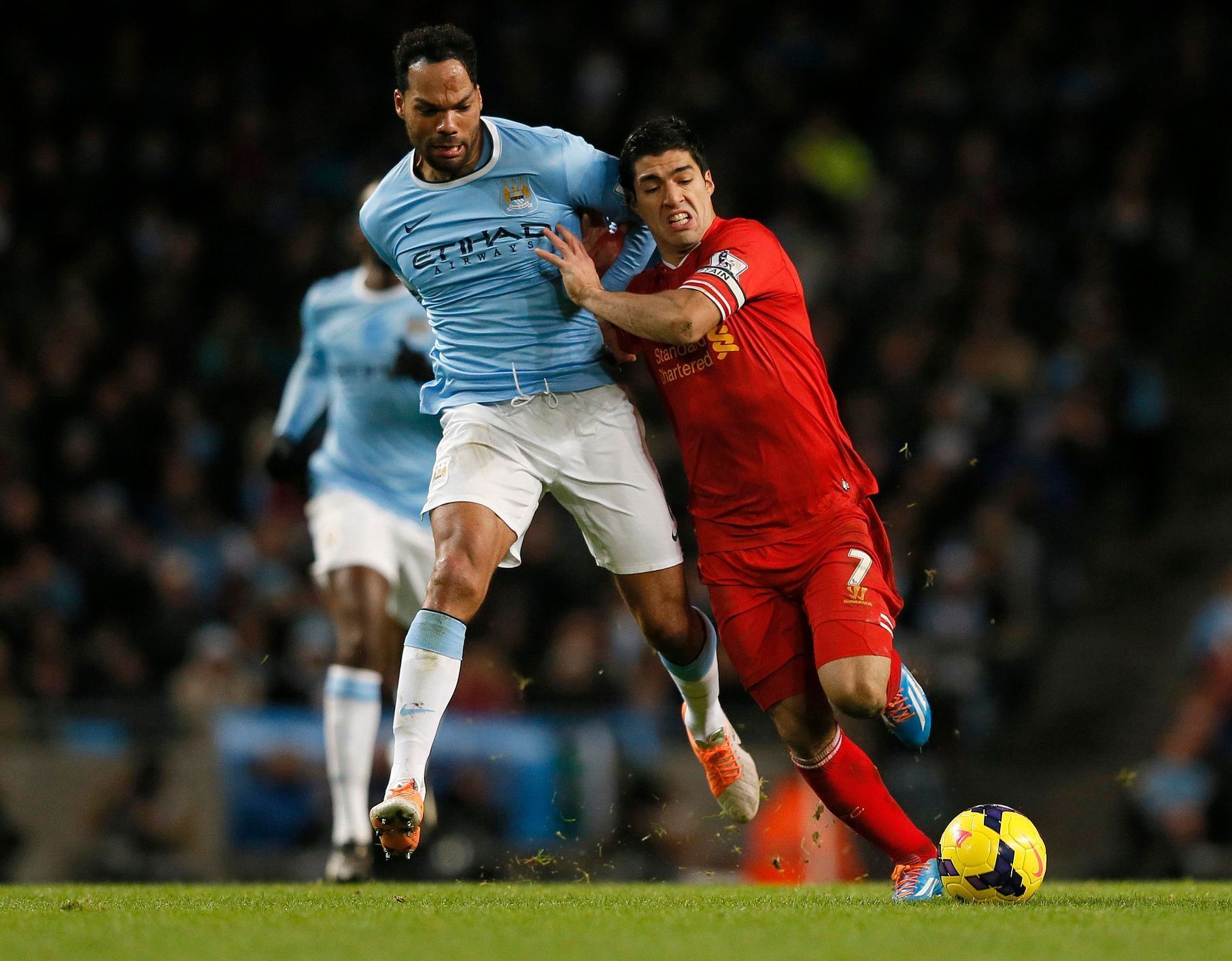 Liverpool's Suarez challenges Manchester City's Lescott  during their English Premier League soccer match at the Etihad stadium in Manchester