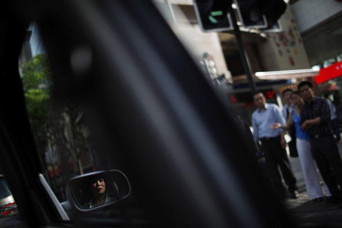 Xiao Cao, a 57-year-old gay man, is reflected in the mirror of a taxi in downtown Shanghai April 28, 2012. China's gay community has long been on the edges of society but it is gradually becoming more accepted. Cao, who is an unemployed drag queen, is one whose life lifts the curtain on a less romanticised view of Chinese homosexuals. Living in an eight-square-metre apartment behind a public toilet and with a monthly income of 500 yuan ($79) from social insurance, he passes his days dancing in public and spending time with friends at gay clubs. Picture taken April 28, 2012. REUTERS/Aly Song (CHINA - Tags: SOCIETY) CHINA OUT. NO COMMERCIAL OR EDITORIAL SALES IN CHINA. ATTENTION EDITORS PICTURE 20 OF 28 OF PACKAGE 'GAY AND OUT IN CHINA' TO FIND ALL IMAGES SEARCH 'GAY OUT CHINA' Published: Čer. 1, 2012, 12:40 dop.