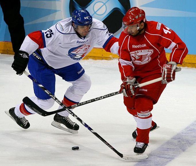 Radoslav Suchy (vlevo, ZSC Lions Curych) a David Hruška (vpravo, HC Slavia Praha) při hře o puk u modré čáry.