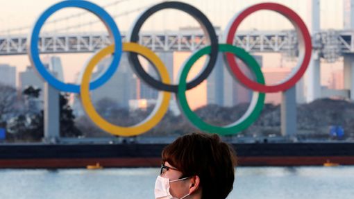 FILE PHOTO: A man wears a protective mask amid the coronavirus disease (COVID-19) outbreak in front of the giant Olympic rings in Tokyo, Japan, January 13, 2021. REUTERS/