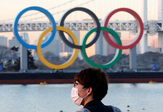 FILE PHOTO: A man wears a protective mask amid the coronavirus disease (COVID-19) outbreak in front of the giant Olympic rings in Tokyo, Japan, January 13, 2021. REUTERS/