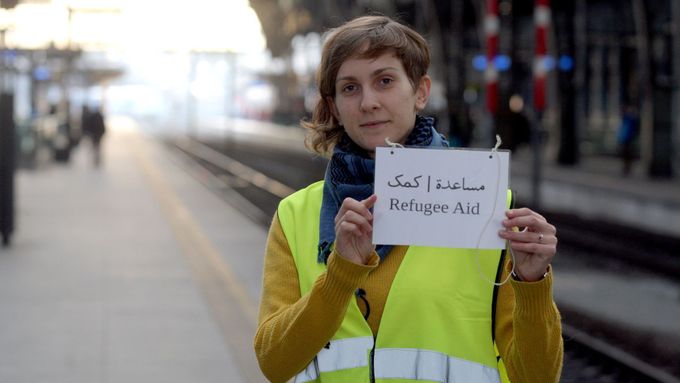 Foto: Dobrovolníci z Hlaváku s cedulkou v arabštině. Za dva měsíce pomohli pěti stovkám běženců