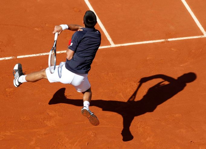 Srbský tenista Novak Djokovič odpálil míček na Šcýcara Rogera Federera během semifinále French Open 2012.