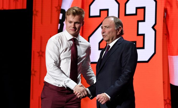 Matvej Mičkov (vlevo) se šéfem NHL Garym Bettmanem při draftu NHL 2023