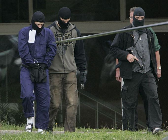 Armed German special police officers escort a handcuffed suspect (L) from the German Federal Court of Justice in Karlsruhe September 5, 2007. Germany has arrested three men it suspects of belonging to an Islamist terrorist group and planning attacks on Frankfurt international airport and a major U.S. military base, German officials said on Wednesday. REUTERS/Wolfgang Rattay (GERMANY)