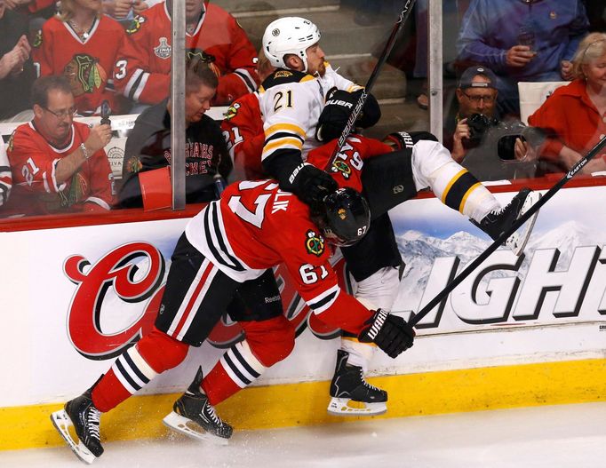 Chicago Blackhawks' Michael Frolik (L) checks Boston Bruins' Andrew Ference during the first period in Game 1 of their NHL Stanley Cup Finals hockey game in Chicago, Illi