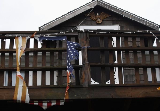 Z americké vlajky zavěšené na průčelí domu v městě Scituate v Massachusetts zbyly díky řádění větrné bouře jen pár cárů.