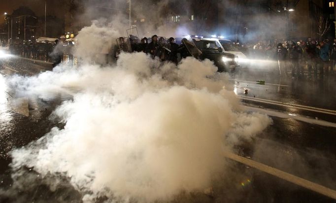 Bulgarian riot police is seen amidst smoke coming from a firecracker, thrown by demonstrators during a protest against high electricity prices in Sofia February 19, 2013. Bulgaria's Prime Minister Boiko Borisov sought to calm protestors on Tuesday by promising slash electricity prices and punish foreign-owned power companies, setting Bulgaria on a collision course with EU partner the Czech Republic. In the capital, protestors clashed with police at a road junction, hurling fire crackers. Eight people were rushed to hospital after the clashes. REUTERS/Stoyan Nenov (BULGARIA - Tags: POLITICS CIVIL UNREST ENERGY BUSINESS) Published: Úno. 19, 2013, 7:43 odp.