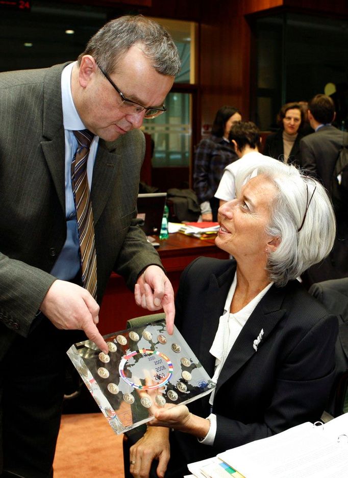 Miroslav Kalousek ukazuje plaketu k desátému výročí založení eura francouzské ministryni financí Christine Lagardeové na mítinku ministrů financí Evropské unie.