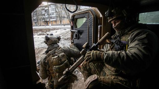 Ukrajinští vojáci vystupují z obrněného vozu.