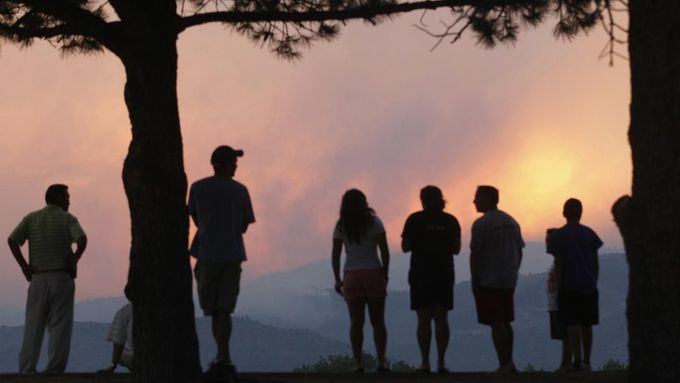 People watch a giant smoke plume rising from the Waldo Canyon Fire during sunset, west of Colorado Springs June 24, 2012. The fast-growing wildfire that blew up overnight in Colorado has forced 11,000 people from their homes and was threatening popular summer camping grounds beneath Pikes Peak, billed as the most visited mountain in North America. REUTERS/Rick Wilking (UNITED STATES - Tags: DISASTER ENVIRONMENT) Published: Čer. 25, 2012, 2:40 dop.