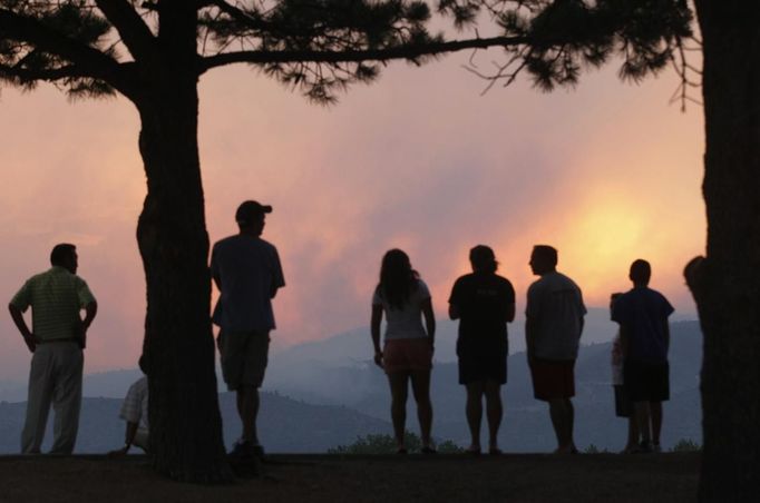 People watch a giant smoke plume rising from the Waldo Canyon Fire during sunset, west of Colorado Springs June 24, 2012. The fast-growing wildfire that blew up overnight in Colorado has forced 11,000 people from their homes and was threatening popular summer camping grounds beneath Pikes Peak, billed as the most visited mountain in North America. REUTERS/Rick Wilking (UNITED STATES - Tags: DISASTER ENVIRONMENT) Published: Čer. 25, 2012, 2:40 dop.