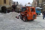 Na Staroměstském náměstí sníh odváží pryč těžká technika.