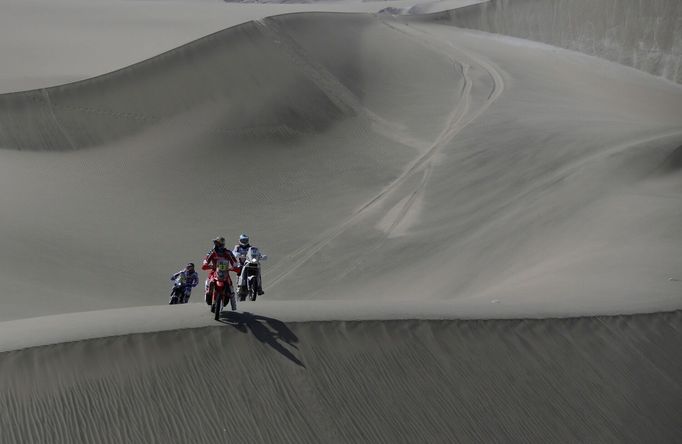 Motocyklisté se opatrně chystají sjezd z písečné duny během druhé etapy Rallye Dakar...