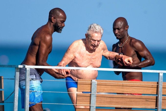 George Soros si užívá den na pláži s doprovodem v západním Barbadosu, 23. prosince 2023.