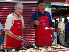 Romney (vpravo) na kampani v Iowě pekl voličům steaky.