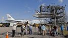 Photographers look on as space shuttle Discovery is approached by a NASA 747 aircraft being towed towed into the Mate Demate facility at Kennedy Space Center in Cape Canaveral