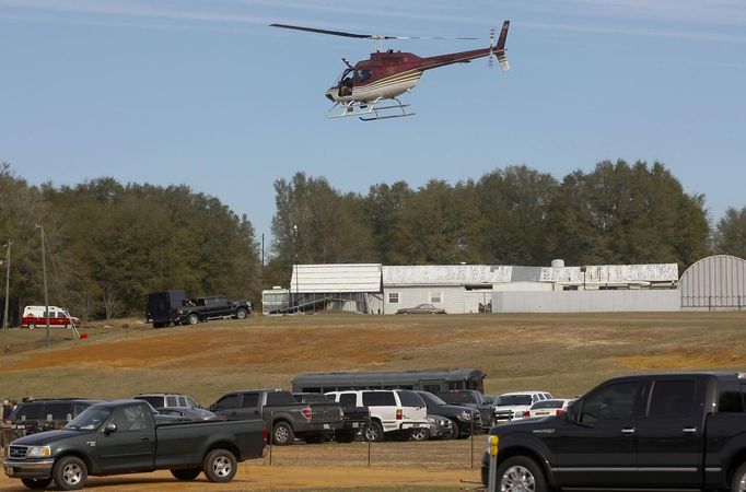 A Dale County Alabama helicopter flies over the scene of a shooting and hostage taking near Midland City, Alabama February 1, 2013. Residents in a rural Alabama town prayed on Friday and called for the release of a 5-year-old boy being held captive for a fourth day by a man accused of shooting a school bus driver and then taking the child hostage. REUTERS/Phil Sears (UNITED STATES - Tags: CRIME LAW) Published: Úno. 1, 2013, 9:33 odp.