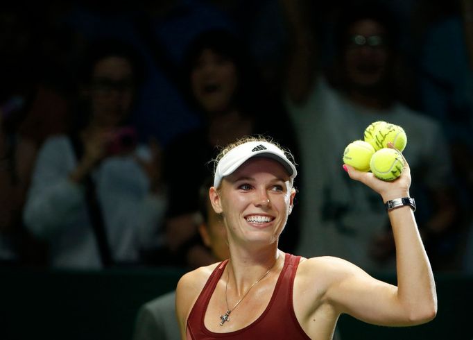 Caroline Wozniacki of Denmark prepares to hit balls to the audience after defeating Agnieszka Radwanska of Poland during their WTA Finals singles tennis match at the Sing