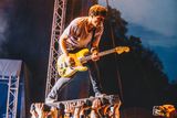 Frontman kapely Itchy stojící nad diváky na festivalu Rockový slunovrat v Řevnicích