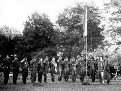 O dva dny později přistál pluk na polním letišti Zolná. Na snímku slavnostní nástup ke vztyčení státní vlajky na improvizovaném stožáru. František Fajtl stojí druhý zprava.