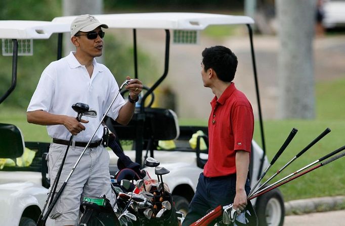 Jedno z dovolenkových potěšení nového prezidenta: Obama si šel do místního klubu zahrát golf. Na snímku diskutuje s jedním ze zaměstnanců Eugenem Kangem - zřejmě o tom, jakou zvolit hůl.