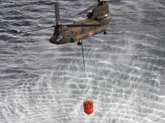 Armádní helikoptéra Chinook CH-47 nabírá vodu z oceánu, aby se z nebe pokusila ochladit třetí fukušimský reaktor. 