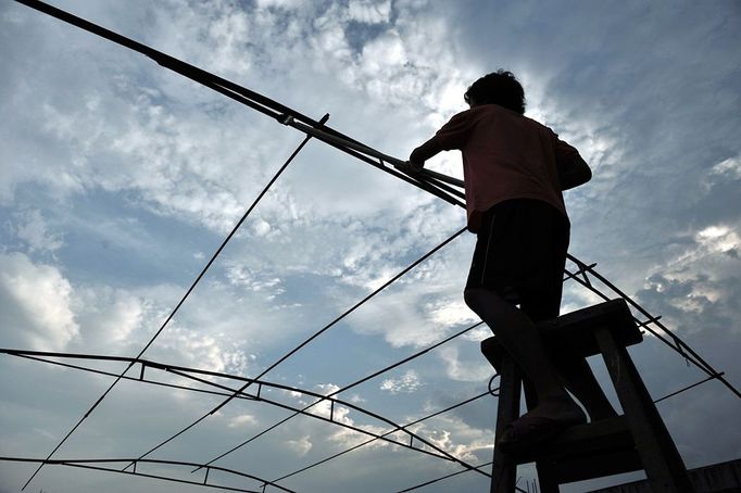 Performing With Lightning CHANGLE, CHINA - AUGUST 11: (CHINA OUT) Wang Zengxiang installs an iron shelf prior to a stunt performance on August 11, 2012 in Changle, Fujian Province of China. Wang Zengxiang, one of the craziest fans of the Tesla coil stunt, has dedicated himself in the daredevil career for a decade. He is now the leader of a band of four. A Tesla coil is an electrical resonant transformer circuit invented by Nikola Tesla around 1891. The transformer produces high voltage at high frequencies, which acts as a giant lightning machine, and creates long bolts of electricity. Shielded by protective clothing, the performer is insulated from the electricity current which dissipates through the ground. ( automatický překlad do češtiny )