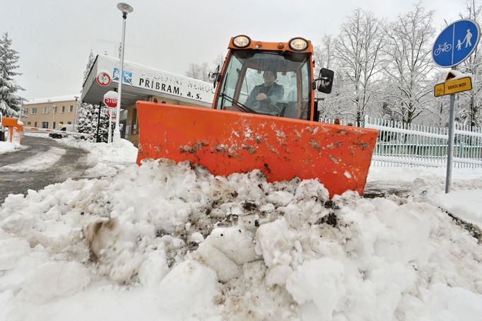 Na snímku pracovník technických služeb odstraňuje sníh z chodníku u příbramské oblastní nemocnice.