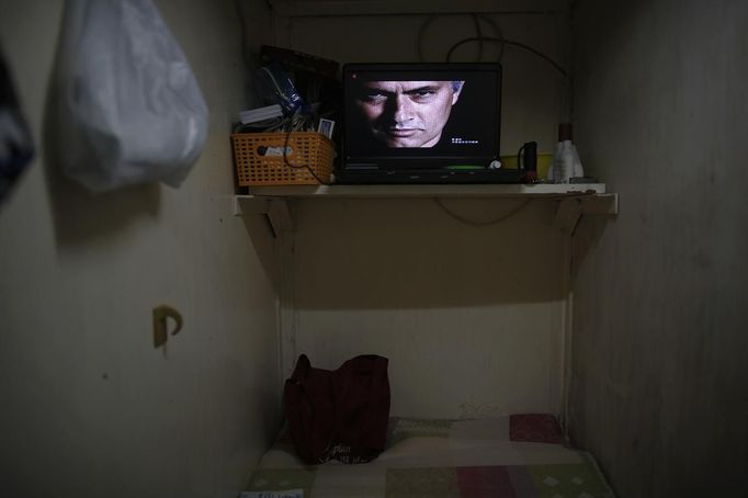 A television placed inside a wooden box used for living is seen in Hong Kong October 9, 2012. In Hong Kong's middle-class residential area, short distance from its shopping and financial districts, 24 people live in these wooden boxes, or "coffin homes", packed in a single apartment of little over 50 square meters. Its residents pay 1450 Hong Kong dollars ($180) for their living space built of wooden panels of 2 meters by 70 cm. To maximize income from the rent in central Hong Kong landlords build "coffin homes", nicknamed due to their resemblance to real coffins. Space has always been at a premium in Hong Kong where developers plant high-rises on every available inch. REUTERS/Damir Sagolj (CHINA - Tags: REAL ESTATE BUSINESS SOCIETY) Published: Říj. 9, 2012, 1:54 odp.