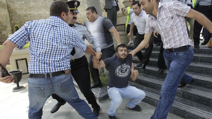 Policisté v civilu zatýkají jednoho z demonstrantů během protestu v Baku.