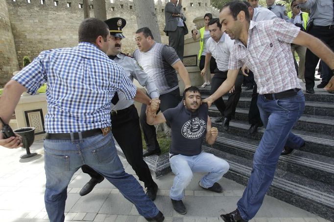 Policisté v civilu zatýkají jednoho z demonstrantů během protestu v Baku.