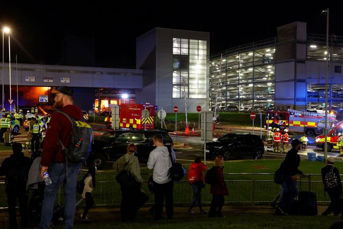 People leave the London Luton airport as emergency services respond to a fire in the Terminal Car Park 2, in Luton, Britain, October 11, 2023.  REUTERS/Peter Cziborra