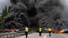 Civil Guard members walks in front of a barricade on the motorway A-66 that was set up by coal miners on strike to protest government spending cuts in the mining sector in Campomanes, near Oviedo, northern Spain, May 29, 2012. Spain's economy is contracting for the second time since late 2009 and four years of stagnation and recession have pushed unemployment above 24 percent, the highest rate in the European Union. REUTERS/Eloy Alonso (SPAIN - Tags: CIVIL UNREST BUSINESS EMPLOYMENT ENERGY) Published: Kvě. 29, 2012, 7:36 odp.