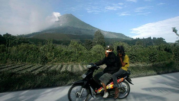 Vesničané ujíždějí pryč od vulkánu Sinabung na severu indonéské Sumatry.