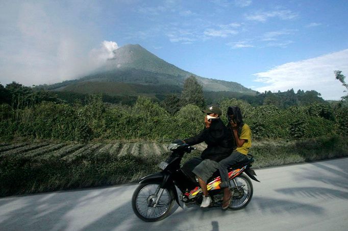 Vesničané ujíždějí pryč od vulkánu Sinabung na severu indonéské Sumatry.