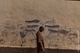 Marco Gualazzini, Krize u jezera Čad. Sirotek jde podél zdi, na které jsou namalovány granátomety.