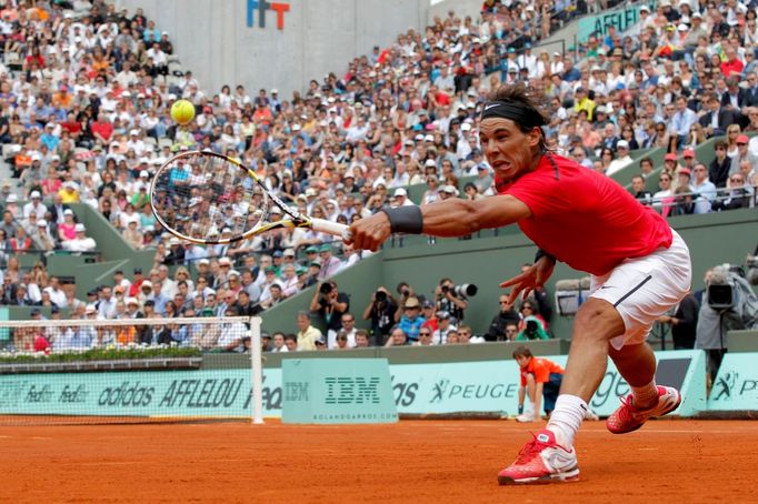 Španělský tenista Rafael Nadal dobíhá míček v utkání s Uzbekem Denisem Istominem během 2. kola French Open 2012.