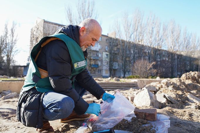 Oleh Kajdašov odebírá vzorky půdy z kráteru po ruském ostřelování Chersonu.