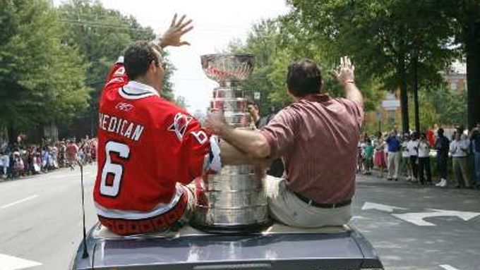 Trenér vítězů Stanley Cupu Caroliny Hurricanes, Peter Laviolette (vpravo) si užívá triumfální jízdu městem s cennou trofejí.