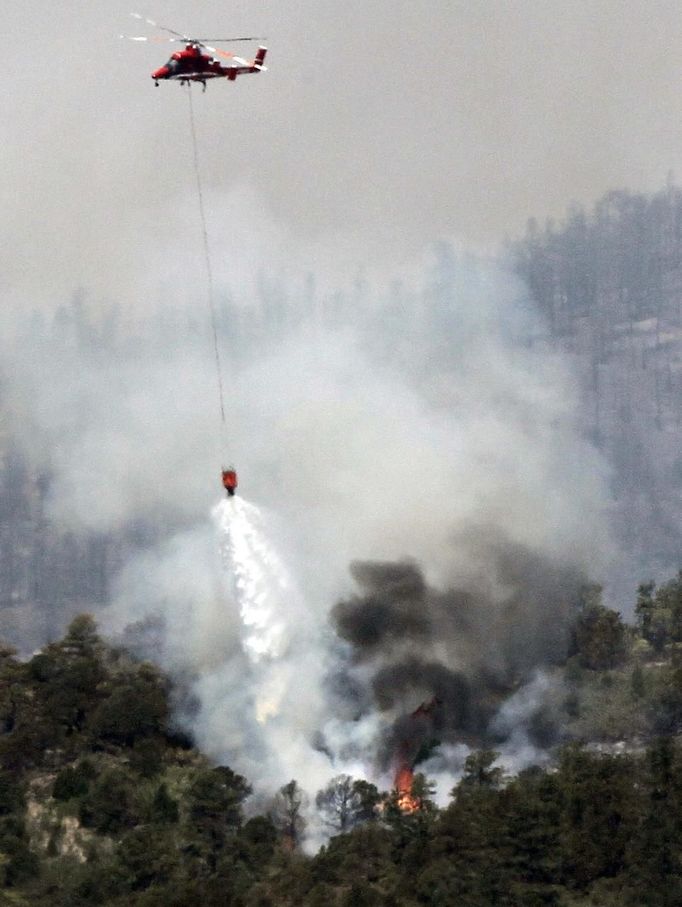 A helicopter drops water on the Waldo Canyon fire west of Colorado Springs, Colorado June 25, 2012. A fast-growing wildfire in Colorado forced 11,000 people from their homes at least briefly and threatened popular summer camping grounds beneath Pikes Peak, whose vistas helped inspire the patriotic tune "America the Beautiful." REUTERS/Rick Wilking (UNITED STATES - Tags: DISASTER ENVIRONMENT) Published: Čer. 25, 2012, 6:04 odp.