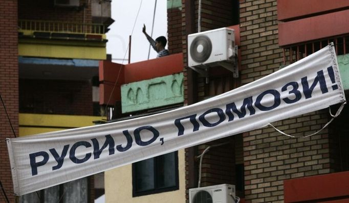 A boy waves from his balcony in the ethnically divided Kosovo town of Mitrovica December 10, 2007. Kosovo Albanian leaders will immediately start talks with their Western backers on steps leading to a declaration of independence, which would take place "much earlier than May", a senior official said on Monday. The banner reads: "Russia Help Us!" REUTERS/Marko Djurica (SERBIA)