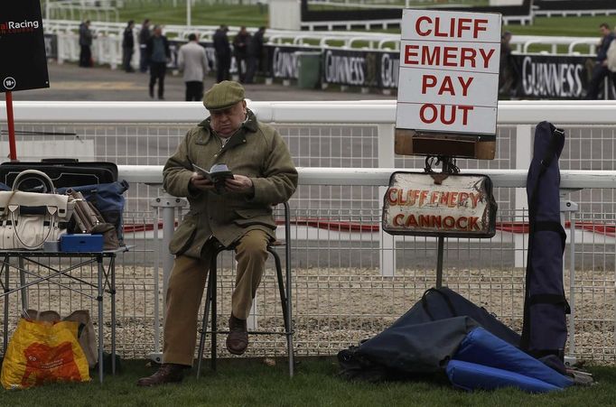 A bookmaker reads a race programme during the Cheltenham Festival horse racing meet in Gloucestershire, western England March 13, 2012.