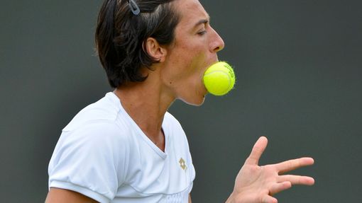 Italská tenistka Francesca Schiavoneová cumlá míček během osmifinálového utkání s Petrou Kvitovou ve Wimbledonu 2012.