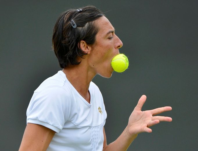 Italská tenistka Francesca Schiavoneová cumlá míček během osmifinálového utkání s Petrou Kvitovou ve Wimbledonu 2012.