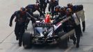 Red Bull Formula One driver Daniel Ricciardo of Australia has his car pushed back in the pit lane during the Malaysian F1 Grand Prix at Sepang International Circuit outsi