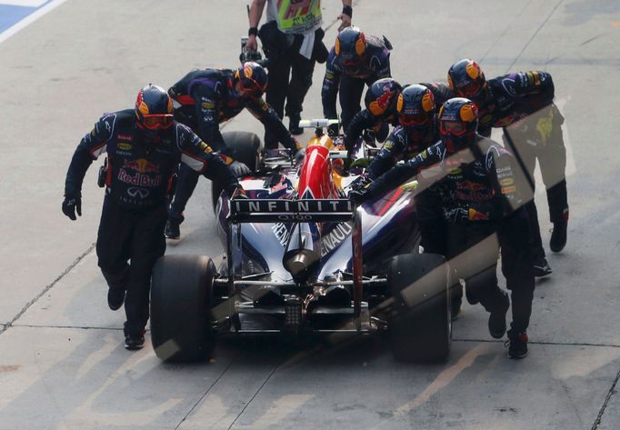 Red Bull Formula One driver Daniel Ricciardo of Australia has his car pushed back in the pit lane during the Malaysian F1 Grand Prix at Sepang International Circuit outsi