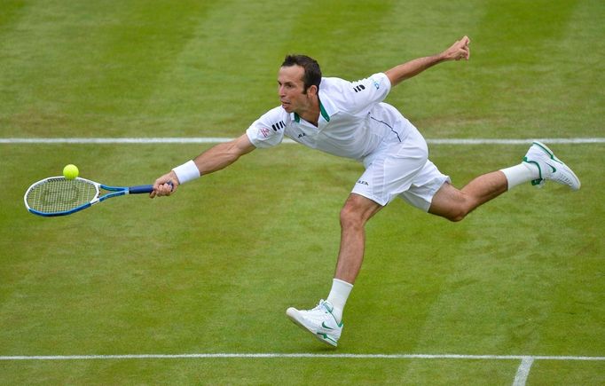 Český tenista Radek Štěpánek dobíhá míček během utkání s Ukrajincem Sergejem Stachovskym v 1. kole Wimbledonu 2012.