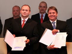 Michal Hašek s Milanem Venclíkem ukazují dohodu o spolupráci ODS a ČSSD krátce po jejím podpisu.